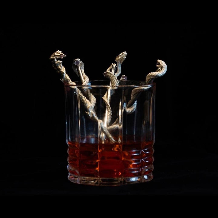 Glass with four Swizzle sticks.